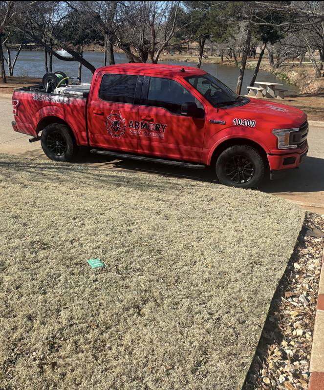 Armory Pest Defense branded service truck parked by a lake